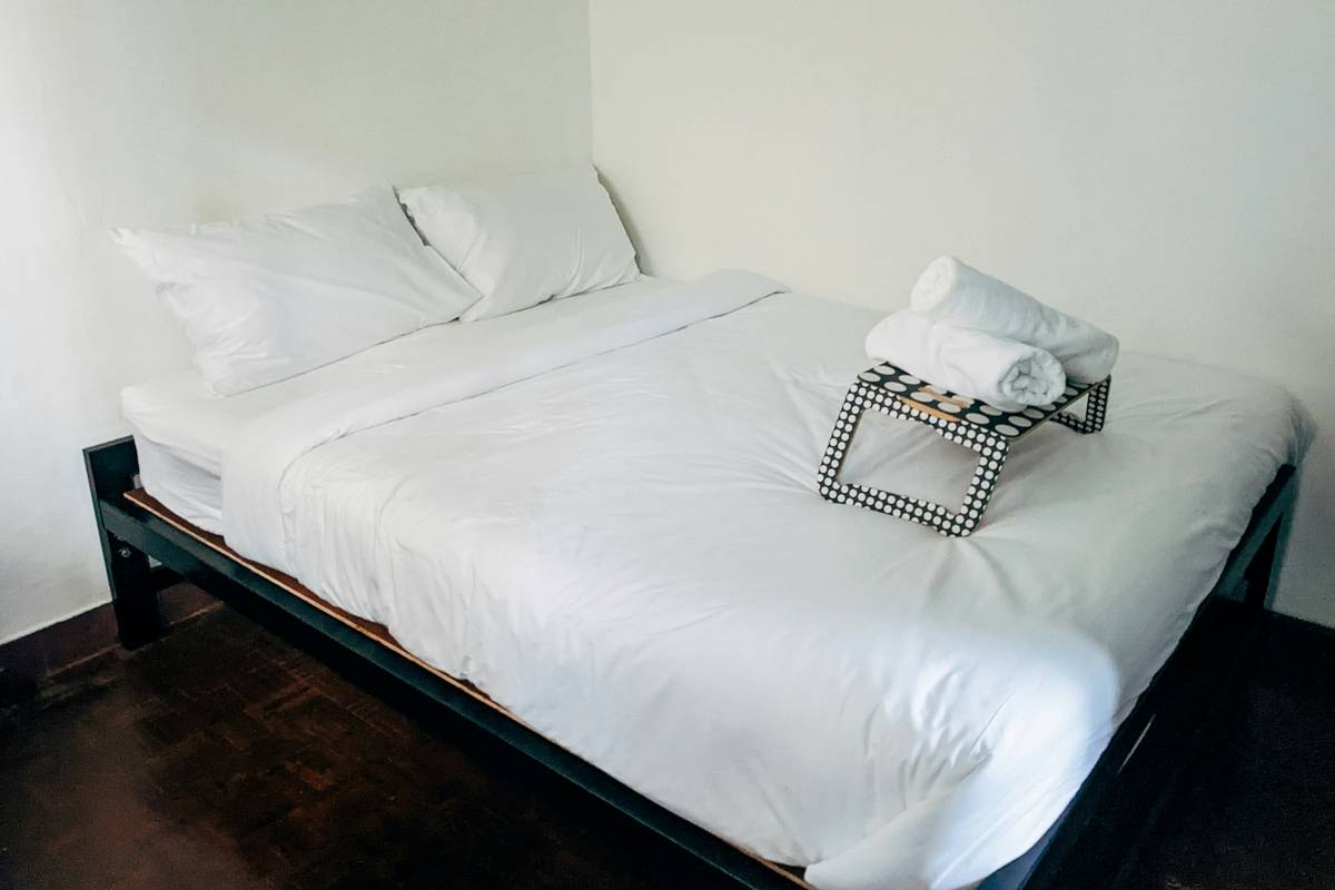 simple minimalist bedroom ideas featuring a platform bed, neutral bedding, and a single wooden nightstand
